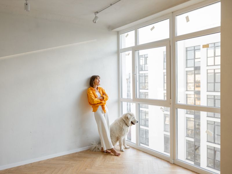 Una chica descalza con su perro en su piso. Imagen que hacer referencia al aislamiento y climatización.