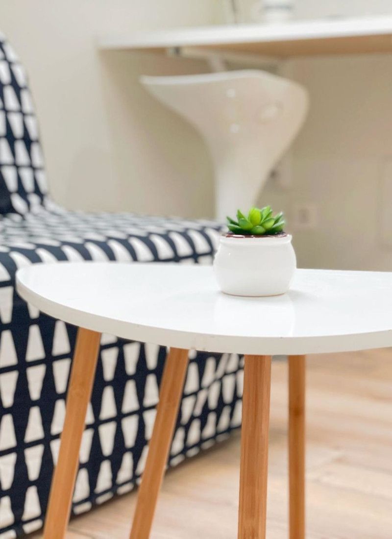 Primer plano de una mesa con una maceta de un apartamento totalmente reformado por Leonesa de reformas.