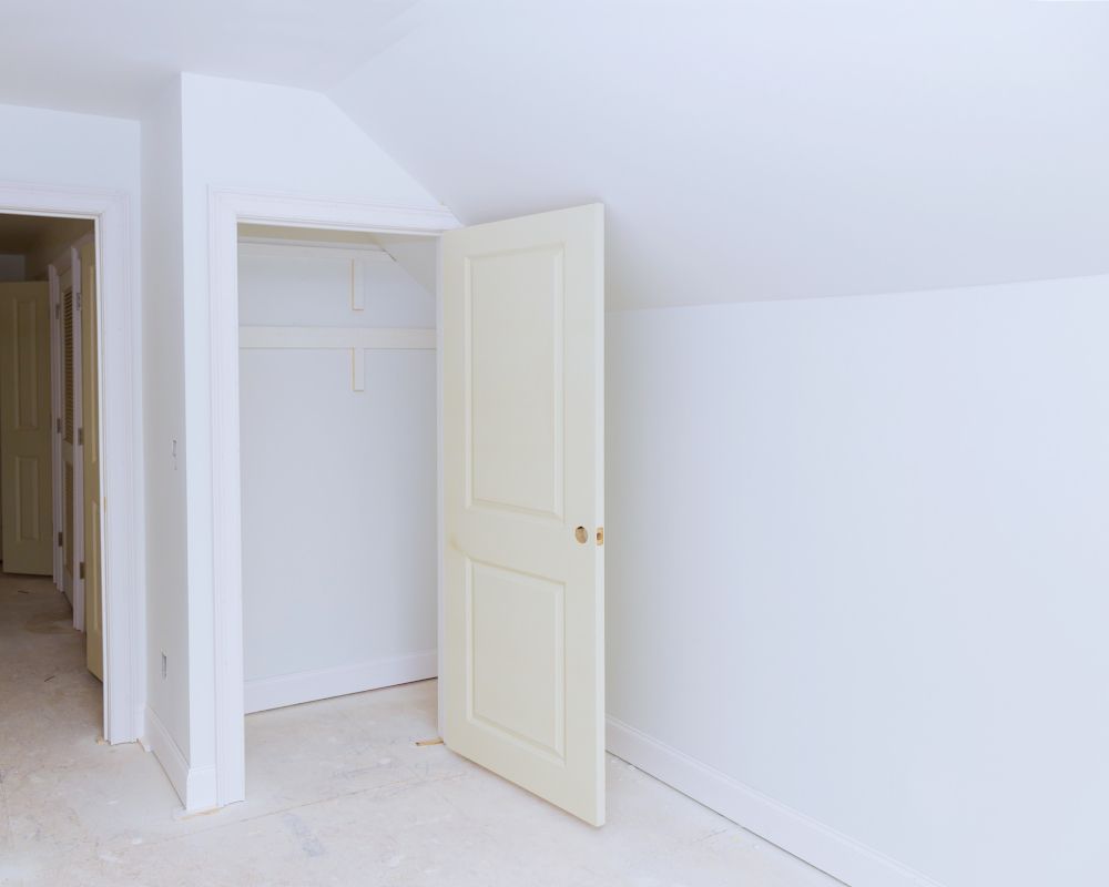 Habitación abuhardillada con la tabiquería y techos ya pintados.